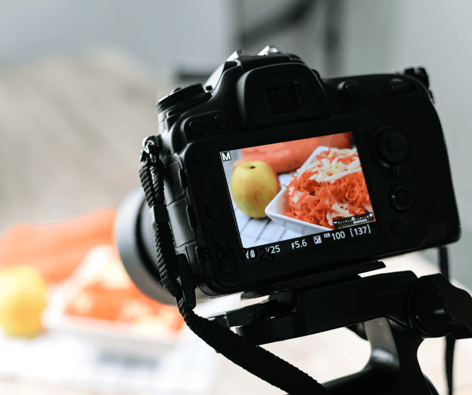 Camera screen displaying a close-up of shredded carrots and an apple on a plate.