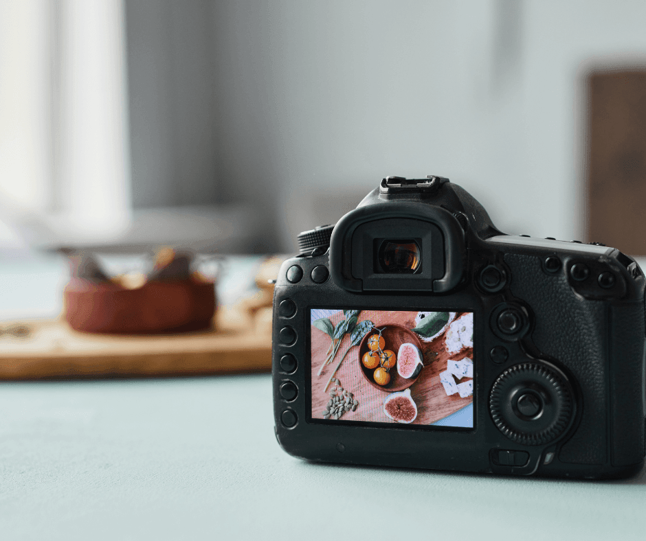 Digital camera displaying a close-up image of figs and nuts on its screen, with blurred background.
